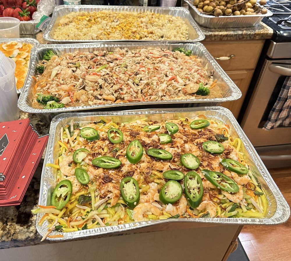 Vietnamese mango salad tray in front of seafood noodles and fried rice